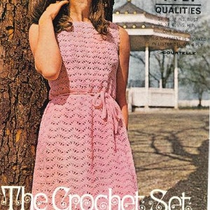 Könnte beinhalten: Eine Frau trägt ein rosa Häkelkleid mit einem gewellten Saum. Das Kleid ist aus einem 4-fädigen Garn gefertigt und trägt unten ein Etikett mit der Aufschrift 'The Crochet Set'. Das Bild zeigt auch den Text 'Lister 4-PLY Qualities' und 'N 2121'.