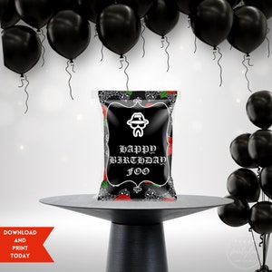 Könnte beinhalten: Schwarze und weiße Partytüte mit roten Rosen und einem Bandana-Druck. Die Tüte hat ein weißes Etikett mit dem Text "Happy Birthday Foo" in einer gotischen Schrift.