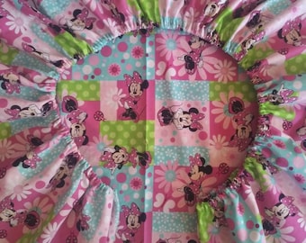 Puede incluir: Una sábana bajera rosa, verde y azul con un diseño de patchwork con Minnie Mouse. La sábana está hecha de algodón y es perfecta para una cama de niño.