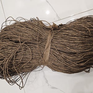 May include: A large bundle of brown paper twine, tightly wound and ready for use in crafts or packaging.