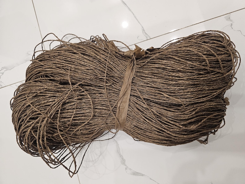 May include: A large bundle of brown paper twine, tightly wound and ready for use in crafts or packaging.