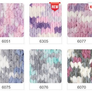 Pu&ograve; includere: Una collezione di dieci campioni di filato in varie combinazioni di colori, tra cui rosa, viola, grigio, bianco e marrone. Il filato &egrave; soffice e testurizzato, con un aspetto a maglia grossa. Ogni campione &egrave; etichettato con un numero.