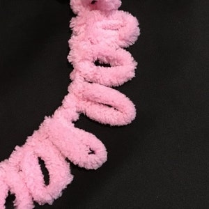 Pu&ograve; includere: Frange rosa soffice con un design ondulato e ad anelli. Questa frangia &egrave; perfetta per aggiungere un tocco di fantasia a qualsiasi progetto.