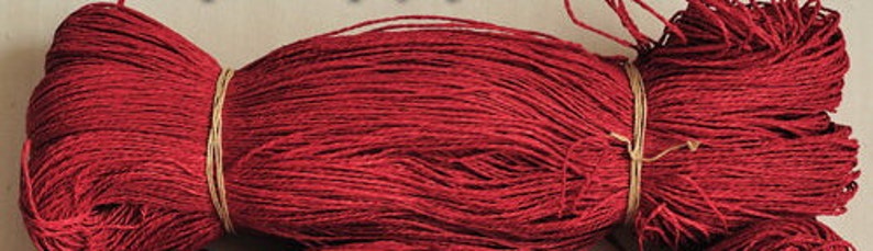 May include: A large spool of deep red yarn, tied with a brown string.