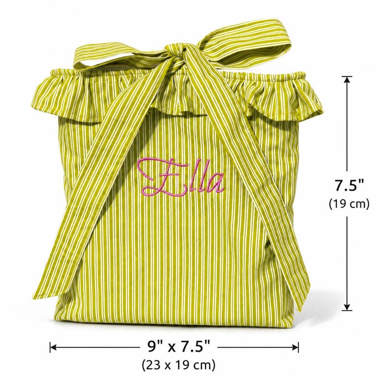 Pu&ograve; includere: Una borsa in tessuto a righe verde lime e bianche con bordo superiore arricciato e un fiocco. Il nome Ella &egrave; ricamato in corsivo rosa sul davanti. La borsa misura 23 cm di larghezza per 19 cm di altezza, come indicato dalle misure visibili.