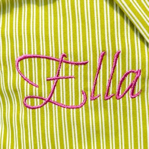 Pu&ograve; includere: Un tessuto a righe verticali verde lime e bianco con il nome Ella ricamato in filo corsivo rosa brillante. Il ricamo &egrave; centrato sul tessuto e mostra un carattere in corsivo cucito in modo netto sul motivo a righe.