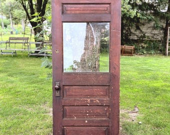 May include: A rectangular wooden door with a dark brown finish, featuring a single glass window pane in the upper section and three horizontal recessed panels below. The door includes a metal doorknob and a keyhole plate on the left side.