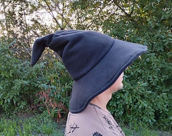 May include: A black wizard hat with a long, pointed tip. The hat is made of a soft, fuzzy material and has a wide brim.