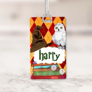 May include: A luggage tag with a red and yellow checkered background. The tag features a brown wizard's hat, a white owl, and a stack of books. The name "harry" is written in green on the tag.