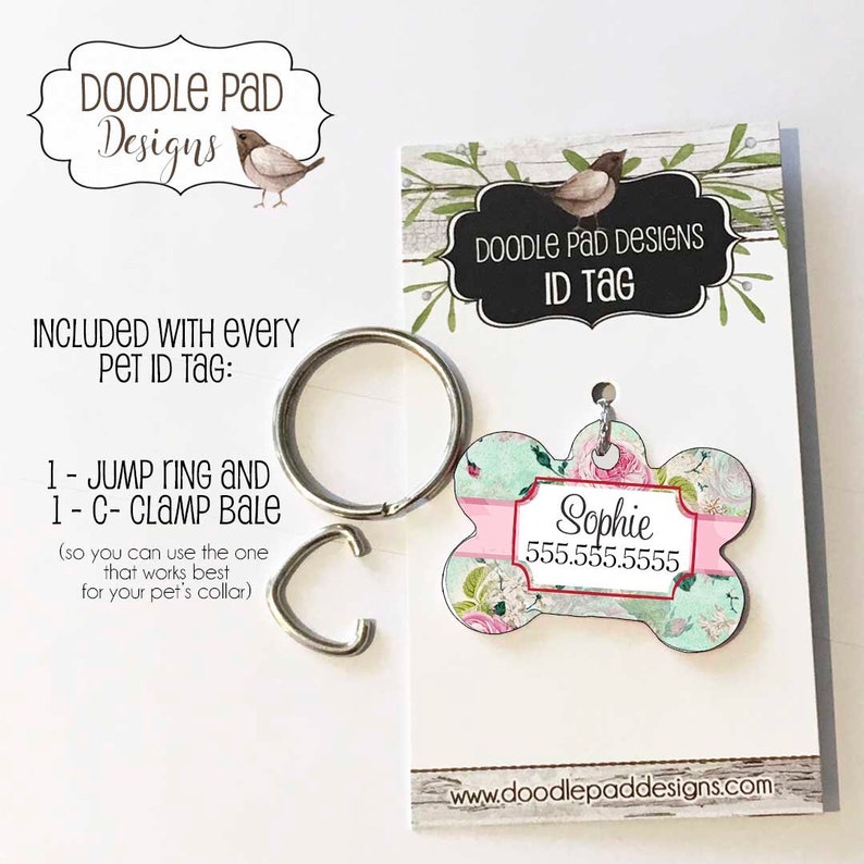 May include: A bone-shaped pet ID tag with a floral design, the name "Sophie" and a phone number. Includes a jump ring and a C-clamp bale for attaching to a pet collar. The tag is from Doodle Pad Designs.
