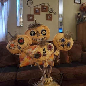 Primitive style pumpkin heads on natural sticks.