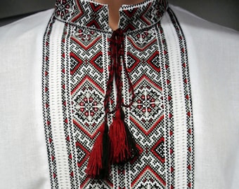 Traditional embroidered handmade vyshyvanka for men. Red and black ornament. Cotton-linen white dress shirt. Ukrainian clothing.