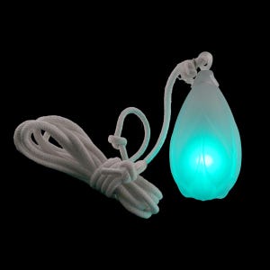 Op de afbeelding: Een druppelvormige lamp met een matwitte buitenkant die van binnenuit een heldere groene gloed uitstraalt. De lamp is bevestigd aan een lang, dik wit gevlochten koord dat in verschillende lussen is gelegd en met knopen is vastgezet.