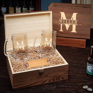 Two engraved beer glasses and a bottle opener inside the personalized wooden box.