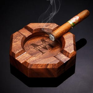 The image highlights the smooth finish and intricate engraving, emphasizing its role as a customized ash tray.
