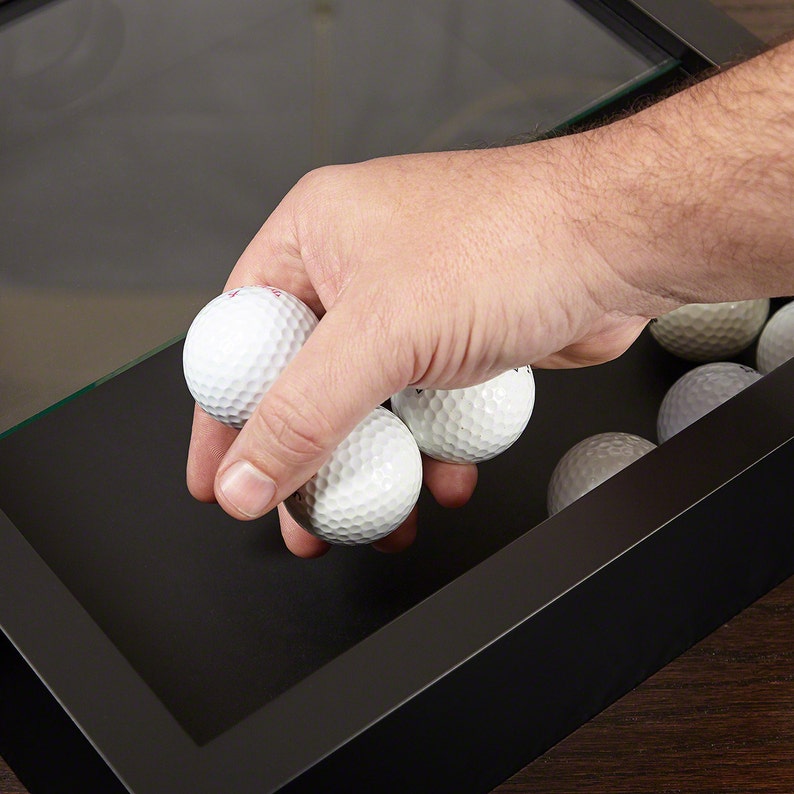 Man putting golf balls in the golf ball holder.