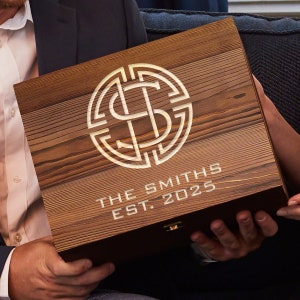 Pu&ograve; includere: Una scatola di legno con un monogramma dorato e il testo "THE SMITHS EST. 2025".