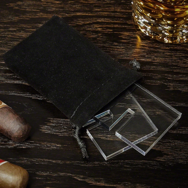K&ouml;nnte beinhalten: Ein schwarzer Samtbeutel mit Kordelzug, der ein Set aus klaren Acryl-Pr&auml;sentationsst&auml;ndern enth&auml;lt. Die St&auml;nder sind &uuml;bereinander gestapelt und so konzipiert, dass sie Objekte aufrecht halten.