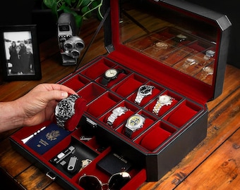 May include: Black leather watch box with a red velvet interior and a glass top. The box has a drawer with a red velvet lining and a small compartment for sunglasses. The box is open and contains several watches.