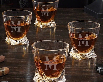 May include: Set of four clear glass whiskey tumblers with a twisted design. Each tumbler is engraved with the letter "M" and the word "MICHAEL".