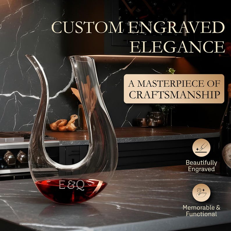 May include: A clear glass wine decanter filled with red wine, engraved with "E&Q". The decanter has a unique, curved design and is displayed on a gray countertop. Text reads "Custom Engraved Elegance" and "A Masterpiece of Craftsmanship".