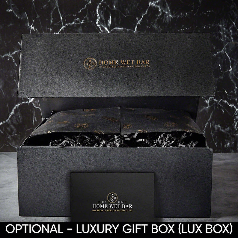 May include: A black gift box with a gold logo that says "Home Wet Bar - Incredible Personalized Gifts". The box is open and filled with black tissue paper and shredded paper.