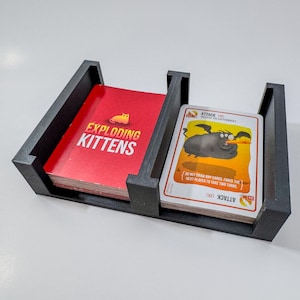 Exploding Kittens game box organizer insert. It is shown in black with the Exploding Kittens Game.