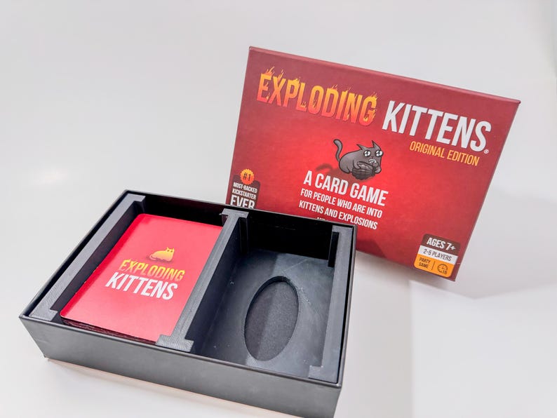 Exploding Kittens game box organizer insert. It is shown in black with the Exploding Kittens Game in the original box.