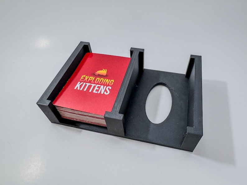 Exploding Kittens game box organizer insert. It is shown in black with the Exploding Kittens Game.