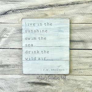 May include: White wooden sign with the quote "live in the sunshine, swim the sea, drink the wild air." - r.w. emerson - Kober's Creations, Ltd.