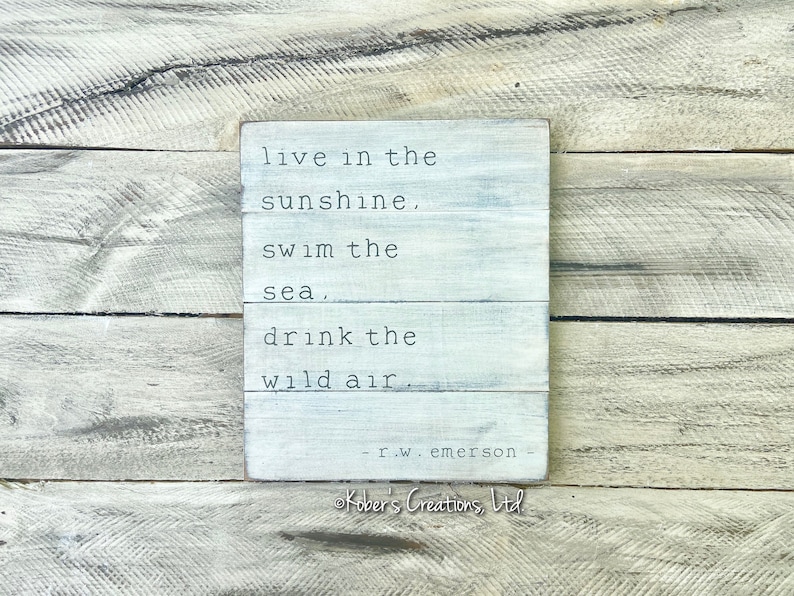 May include: White wooden sign with the quote "live in the sunshine, swim the sea, drink the wild air." - r.w. emerson - Kober's Creations, Ltd.