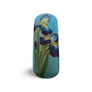 May include: A blue ceramic vase with a floral design of blue and yellow irises.