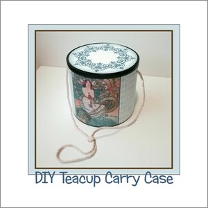 Puede incluir: Una caja de transporte para taza de té DIY con un fondo blanco y una tapa decorativa con un diseño floral azul y negro. La caja tiene un asa de cuerda blanca y una imagen vintage de una mujer en el lateral.