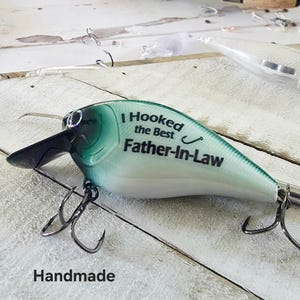 A handmade fishing lure with the text "I Hooked the Best Father-in-Law" printed on it.
