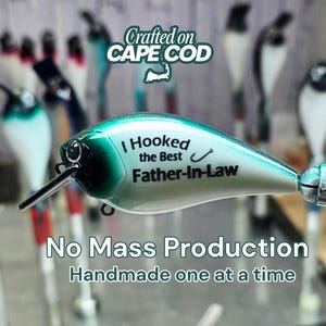 A close-up of a fishing lure with the text "I Hooked the Best Father-In-Law" printed on it, along with the text "No Mass Production Handmade one at a time" below it.
