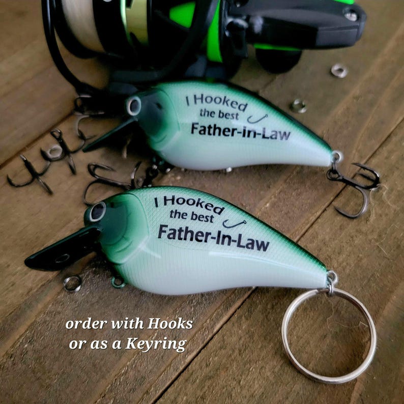 two green and white fishing lures with the text "I Hooked the best Father-in-Law" printed on them, along with a keyring.