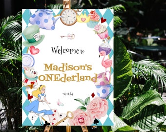 May include: A white welcome sign with a blue and white checkered border. The sign features a whimsical Alice in Wonderland theme with illustrations of Alice, the Mad Hatter, a teapot, a flamingo, and a cupcake. The text on the sign reads "Welcome to Madison's ONEDERLAND 04.11.24".