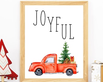 May include: A framed print with the word "JOYFUL" in black text. A red vintage truck with a green Christmas tree and wrapped gifts in the bed of the truck is pictured below the text.