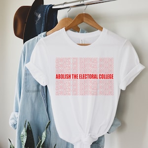 May include: White t-shirt with the phrase "ABOLISH THE ELECTORAL COLLEGE" repeated in red text.