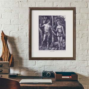 Op de afbeelding: Een zwart-witdruk van een man en een vrouw die in een bos staan. De man houdt een tak in zijn rechterhand en de vrouw houdt een tak in haar linkerhand. De print is ingelijst in een bruin houten lijst.
