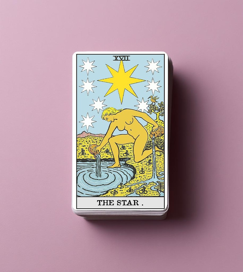 Puede incluir: Una carta de tarot rectangular titulada THE STAR con el n&uacute;mero romano XVII. La ilustraci&oacute;n muestra una figura amarilla arrodillada junto a un estanque azul, vertiendo agua de dos jarras. Una gran estrella amarilla est&aacute; rodeada por siete estrellas blancas.