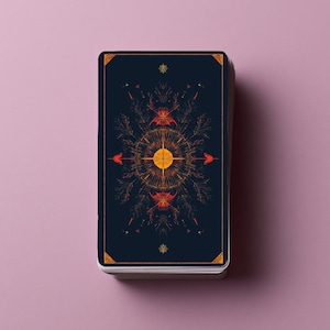 Puede incluir: Una baraja de cartas rectangulares con fondo azul marino oscuro. El reverso de la carta superior presenta un dise&ntilde;o sim&eacute;trico de rayos de sol en naranja y amarillo, rodeado de intrincadas l&iacute;neas bot&aacute;nicas y detalles en las esquinas.