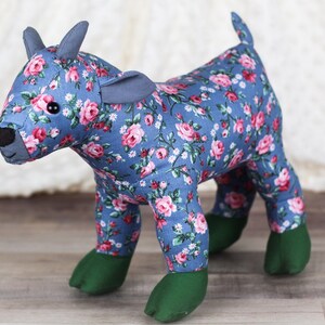 May include: A blue and pink floral patterned stuffed toy goat with green feet.