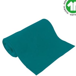 Könnte beinhalten: Eine Rolle tealfarbener Stoff mit dem Global Organic Textile Standard (GOTS) Zertifizierungslabel.
