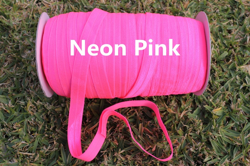 May include: A spool of neon pink elastic ribbon. The ribbon is wound around a cardboard spool with a white label that says "Neon Pink".