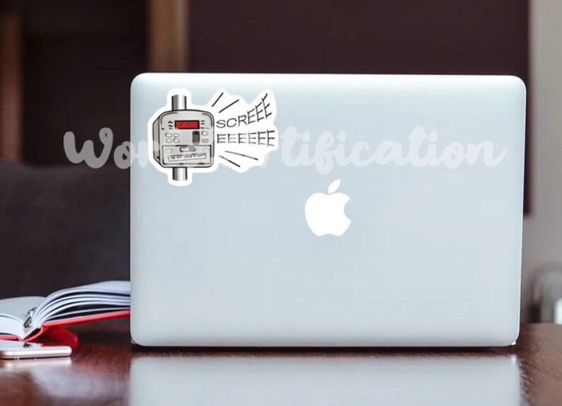 May include: A white laptop computer with a sticker of a utility meter with a red digital display and the word "SCREEEEEE" coming out of it. The laptop has a white Apple logo.