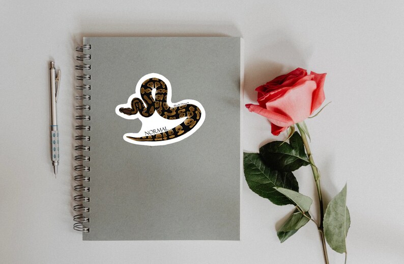 May include: A sticker featuring a black and brown snake with the word "NORMAL" printed on it.