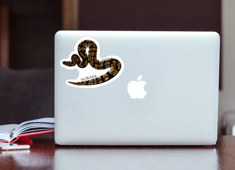 May include: A sticker of a brown and black snake with the word "NORMAL" printed below it.