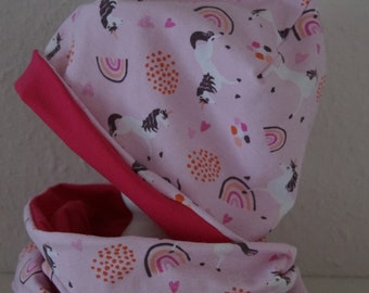 May include: Pink and red fabric unicorn hat and scarf set with a rainbow and polka dot pattern.