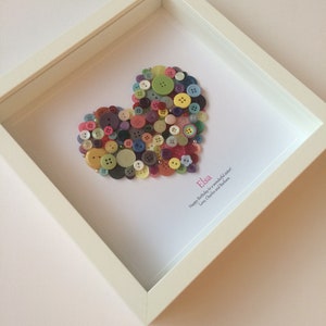 May include: A framed heart made of colorful buttons with the name "Elsa" and the message "Happy Birthday to a wonderful sister! Love, Charles and Barbara" written below.